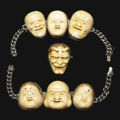 a close up of a bracelet with a bunch of faces on it