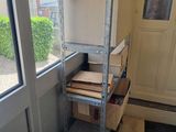 a stack of boxes on a metal shelf next to a window