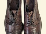pair of brown leather shoes with laces on them against a white background