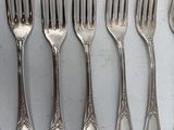 a lot of forks and spoons that are on the table
