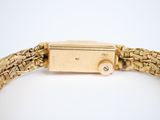 an image of a close up of a gold watch on a white surface