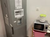 a small kitchen with a refrigerator, microwave and a table