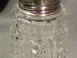 a glass jar with a silver lid sitting on a table