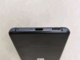 the back of a black cell phone sitting on top of a table