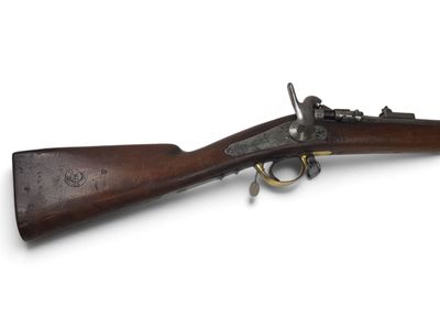 un vieux fusil avec un canon en bois et des garnitures en laiton