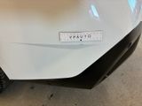 a close up of a white car with a sticker on it