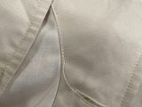 the back of a white shirt with a button on it