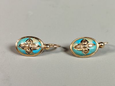 a pair of gold and turquoise earrings with flowers on them