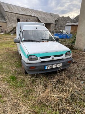un camion garé dans l'herbe devant une grange