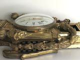 a gold clock sitting on top of a white table