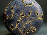 a black and gold clock with gold flowers on it