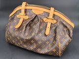 a louis vuitton handbag on a black background