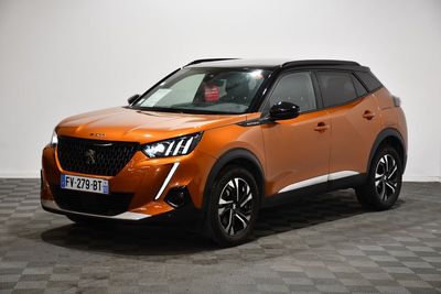 Le SUV orange est garé sur un sol à damier dans une pièce
