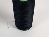 a spool of black thread sitting on top of a white surface