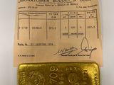 a gold bar sitting on top of a piece of paper