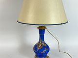 a blue lamp with a gold base and a blue shade