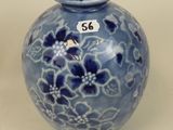 a blue vase with flowers on it sitting on a table