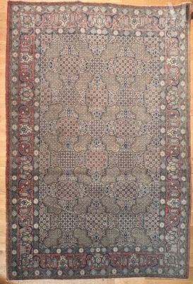 un tapis persan antique sur un plancher en bois