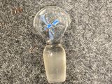 a glass bottle with a blue flower inside of it