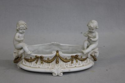 un bol blanc et doré orné de deux cherensils