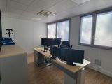 une pièce équipée d'un bureau, de deux écrans et d'un téléviseur