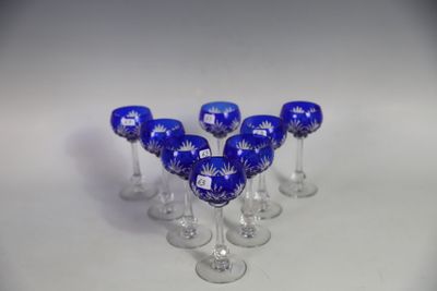six wine glasses are lined up in a row on a white surface