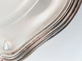 a close up of a silver plate on a white surface