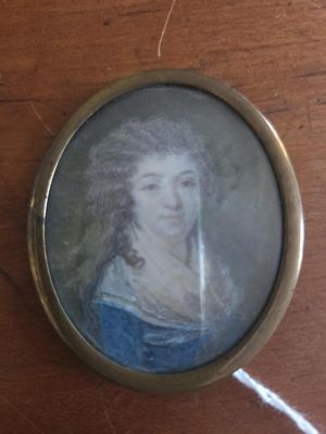 a miniature picture of a woman in a blue dress on a table