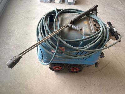 une machine bleue à laquelle est raccordé un tuyau