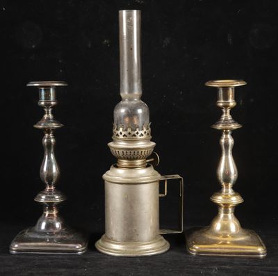 trois bougeoirs en argent posés les uns à côté des autres sur une table