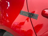 a sticker on the side of a red car that has a ruler attached to it
