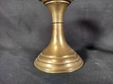 a gold vase with a clock on it on a black background