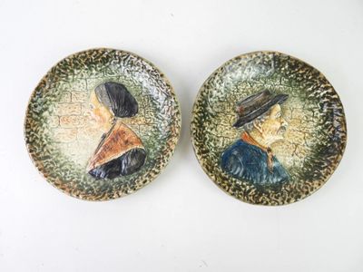 pair of ceramic portraits of a woman and a man on a plate