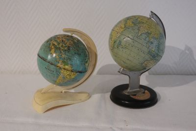 deux petits globes posés sur un socle, sur une table
