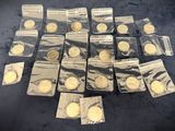 some of the gold coins are in plastic bags on a blue surface