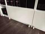 a white radiator that is next to a book shelf