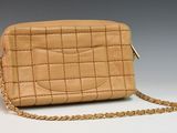 an image of a tan purse with a chain around it