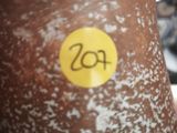 a brown vase with a yellow sticker on it
