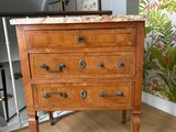 une commode en bois avec un plateau en marbre dans une pièce