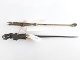 deux objets en bronze et en verre vert posés sur une surface blanche