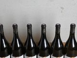 six bottles of wine are lined up in a row on a table
