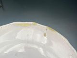 a white plate with yellow spots on it sitting on a table