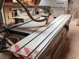 a machine that is cutting a piece of wood in a room
