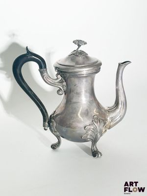 une théière en argent avec une anse noire sur fond blanc