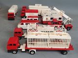 several toy fire trucks are lined up on a gray surface