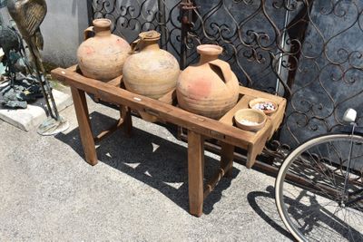 three vases sitting on a wooden stand next to a bike