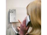 blond woman talking on a cell phone while holding a cord to a wall