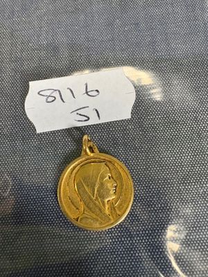 un gros plan d'une médaille d'or posée sur un morceau de tissu