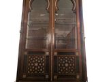 an antique wooden display cabinet with glass doors and ornate carvings