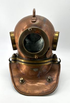 a close up of a copper diving helmet on a white background